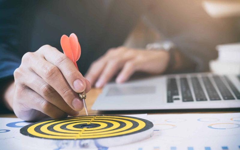 Businessman holding red dart push on target. Business strategy planning success target goals. Business development concept